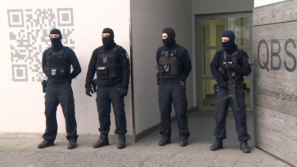 Police stand in front of a residential building in Berlin, Germany, Tuesday, Feb. 28, 2017 after a raid in connection with the ban of the Fussilet 33 organization. (TeleNewsNetwork/dpa via AP)