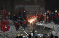 Members of rescue services search for survivors in the debris of a collapsed building in Izmir, Turkey, Monday, Nov. 2, 2020. In scenes that captured Turkey's emotional roller-coaster after a deadly earthquake, rescue workers dug two girls out alive Monday from the rubble of collapsed apartment buildings three days after the region was jolted by quake that killed scores of people. Close to a thousand people were injured. (AP Photo/Darko Bandic)