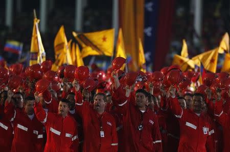 Workers of state-run oil company PDVSA salute Venezuela's President Nicolas Maduro during a parade at the military academy in Caracas April 19, 2013. REUTERS/Tomas Bravo