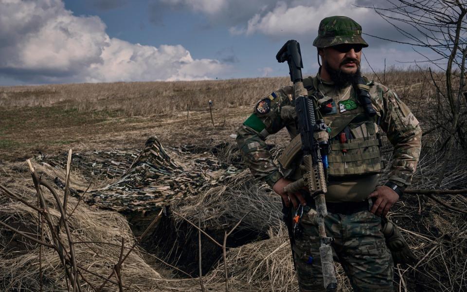 A Ukrainian soldier of the 28th brigade stands near a trench on the frontline near Bakhmut - Libkos/AP