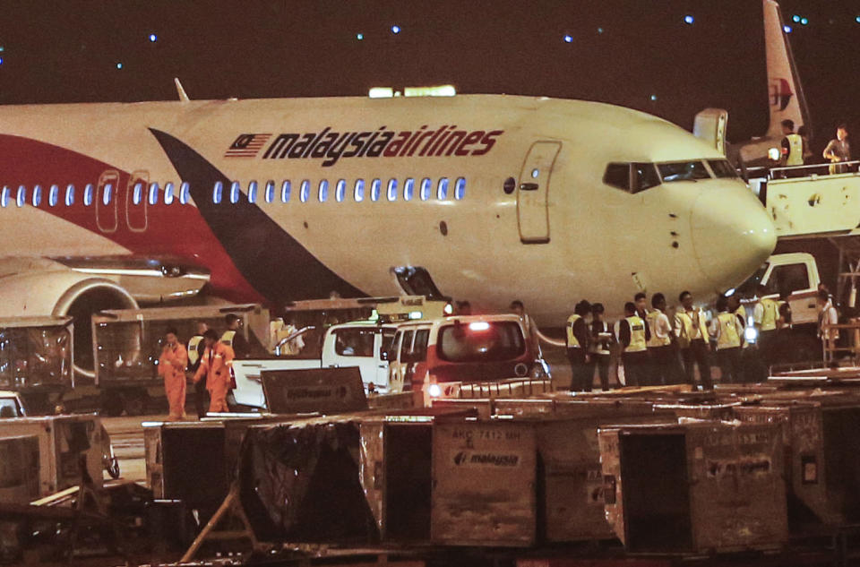 Ground crew check the Malaysia Airlines flight MH192 bound for Bangalore that turned back towards and parked at Kuala Lumpur International Airport in Sepang, Malaysia, Monday, April 21, 2014, after its right landing gear malfunctioned upon takeoff. The airline says Flight 192 carrying 166 people landed safely at the Kuala Lumpur International Airport early Monday, four hours after it departed. (AP Photo/Vincent Thian)