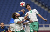 Saudi Arabia's Abdulbasit Hindi, right, heads a ball beside his teammates Yasser Alshahrani during a men's soccer match against Brazil at the 2020 Summer Olympics, Wednesday, July 28, 2021, in Saitama, Japan. (AP Photo/Martin Mejia)