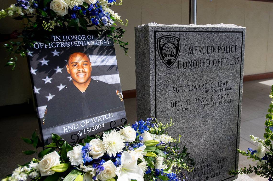 A photo of fallen Merced police officer Stephan Gray is displayed next to a memorial during an annual ceremony to honor Gray at the Merced Police Station in Merced, Calif., on Monday, April 15, 2024. Gray was shot and killed in the line of duty on April 15, 2004.