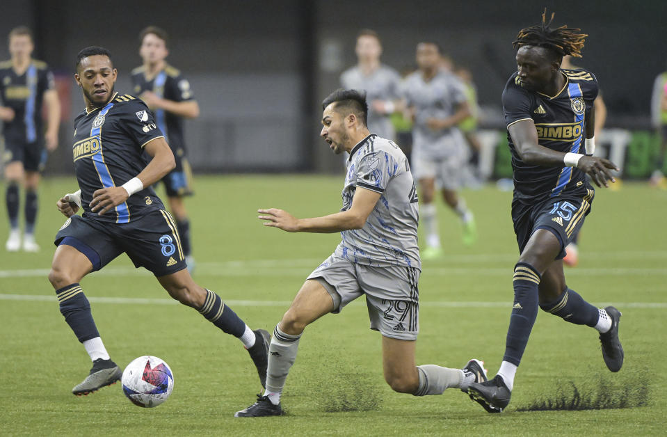 CF Montreal's Mathieu Choiniere (29) trips as Philadelphia Union's Jose Martinez (8) and Olivier Mbaizo (15) defend during second-half MLS soccer match action in Montreal, Saturday, March 18, 2023. (Graham Hughes/The Canadian Press via AP)