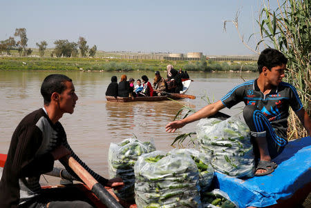 Displaced Iraqis from Mosul cross the Tigris by boat as flooding after days of rainfall has closed the city's bridges, at the village of Thibaniya, south of Mosul, Iraq April 16, 2017. REUTERS/Muhammad Hamed