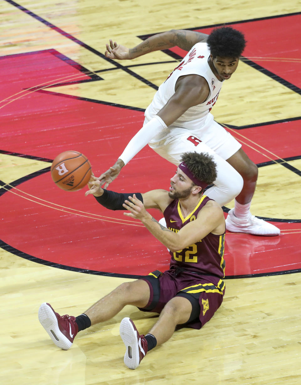 Minnesota guard Gabe Kalscheur (22) plays the ball from the floor as Rutgers center Myles Johnson (15) defends during the first half of an NCAA college basketball game Thursday, Feb. 4, 2021, in Piscataway, N.J. (Andrew Mills/NJ Advance Media via AP)