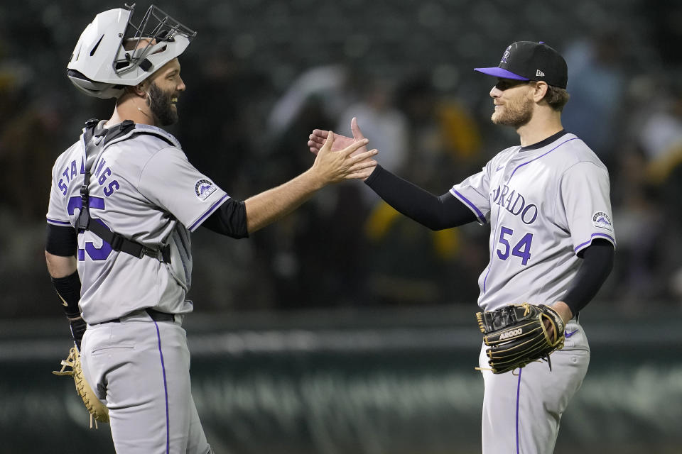 Colorado Rockies catcher Jacob Stallings, left, celebrates with pitcher Matt Koch after the Rockies defeated the Oakland Athletics 4-3 in 12 innings in a baseball game in Oakland, Calif., Wednesday, May 22, 2024. (AP Photo/Jeff Chiu)