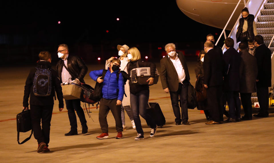 Czech diplomats and their families arrive at the Vaclav Havel airport in Prague, Czech Republic, Monday, April 19, 2021. Russia has ordered 20 Czech diplomats to leave the country within a day in response to Prague's expulsion of 18 Russian diplomats. The Czech government has alleged the Russian Embassy staffers were spies for a military intelligence agency that was involved in a fatal ammunition depot explosion in 2014. (AP Photo/Petr David Josek)