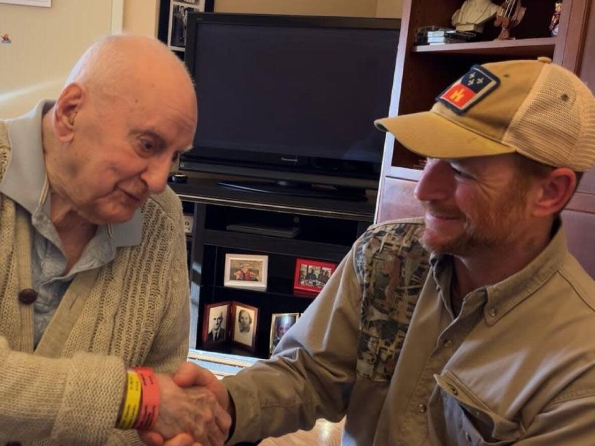 Louisiana native Jason Theriot (right) shakes hands with Acadian naval veteran Camille Leblanc at the Moncton Veterans' Health Centre in October of last year. (Submitted Jason Theriot - image credit)