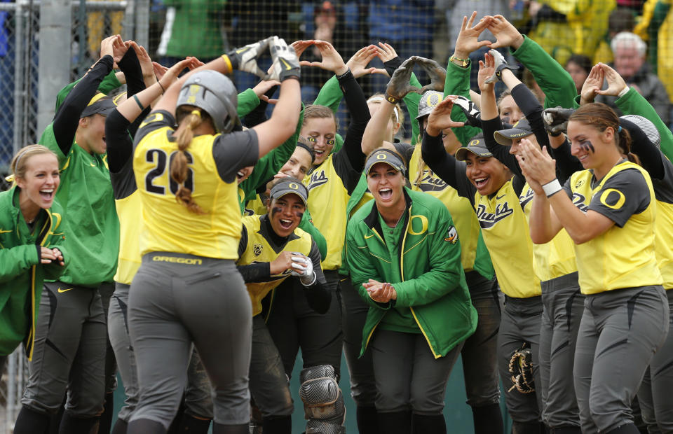 Oregon teammates welcome Janelle Lindvall, left, at home plate after her home run in the seventh inning against Wisconsin in an NCAA regional softball game at Howe Field in Eugene, Ore., Saturday, May 18, 2013. (AP Photo/Chris Pietsch)