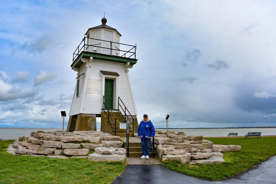 Captain Peg VanVleet stands next to the Port Clinton Lighthouse on May 1. After this fishing season, she will retire from the charter business to focus on lake advocacy. VanVleet, who has been fishing on Lake Erie since she was a young girl, has extensive knowledge about lake threats and how to address them.