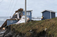 <p>People look at their damaged home after the arrival of Hurricane Fiona in Port Aux Basques, Newfoundland, Canada September 25, 2022. REUTERS/John Morris</p> 