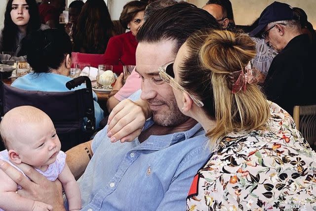 <p>Kaley Cuoco/ Instagram</p> Kaley Cuoco kisses her boyfriend Tom Pelphrey on the cheek as he holds on to their daughter Matilda