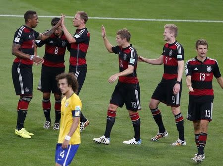 Germany's players celebrate past Brazil's David Luiz after Andre Schuerrle (2nd R) scores his team's sixth goal against Brazil during their 2014 World Cup semi-finals at the Mineirao stadium in Belo Horizonte July 8, 2014. REUTERS/David Gray