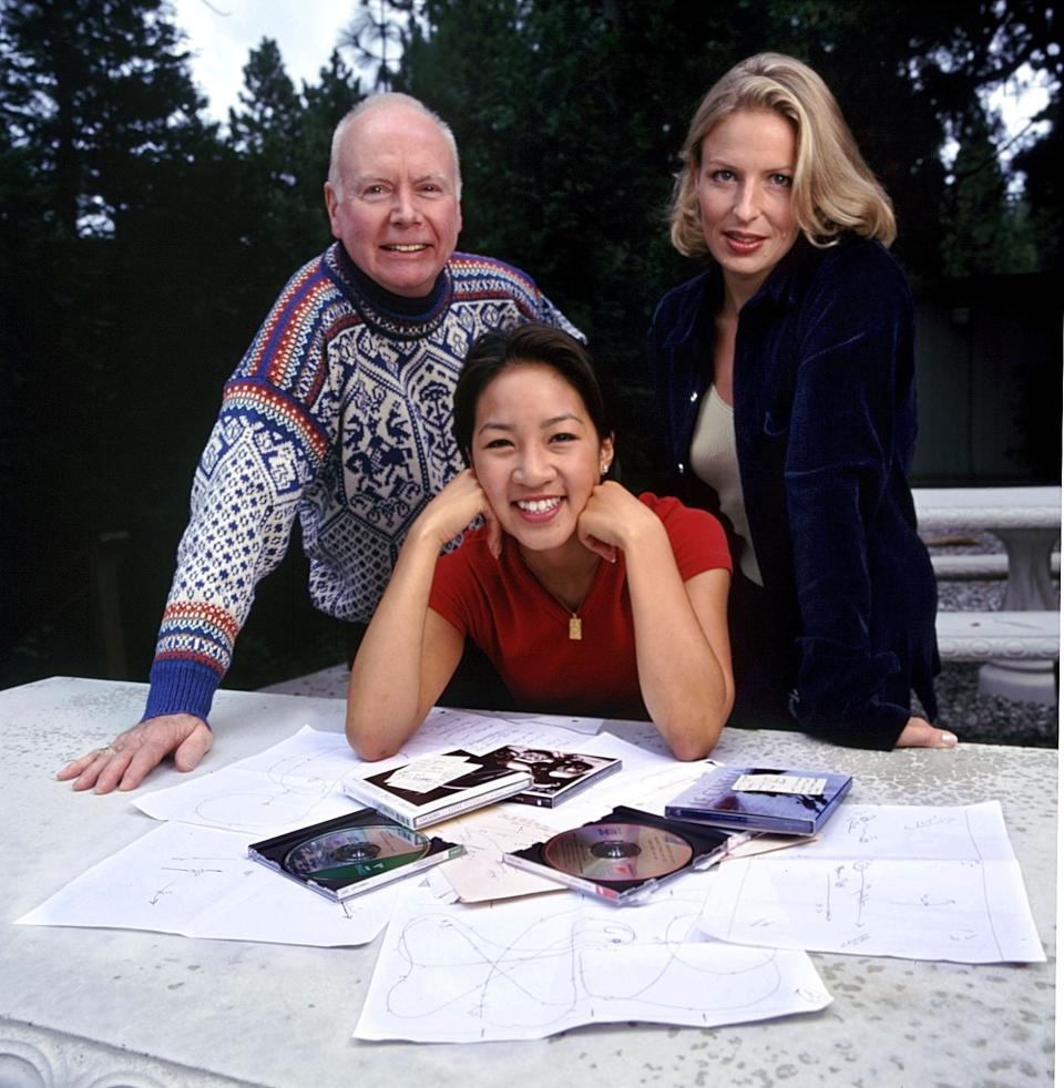 In a file photo from 1998, Michelle Kwan poses with coach Frank Carroll and choreographer Lori Nichol.