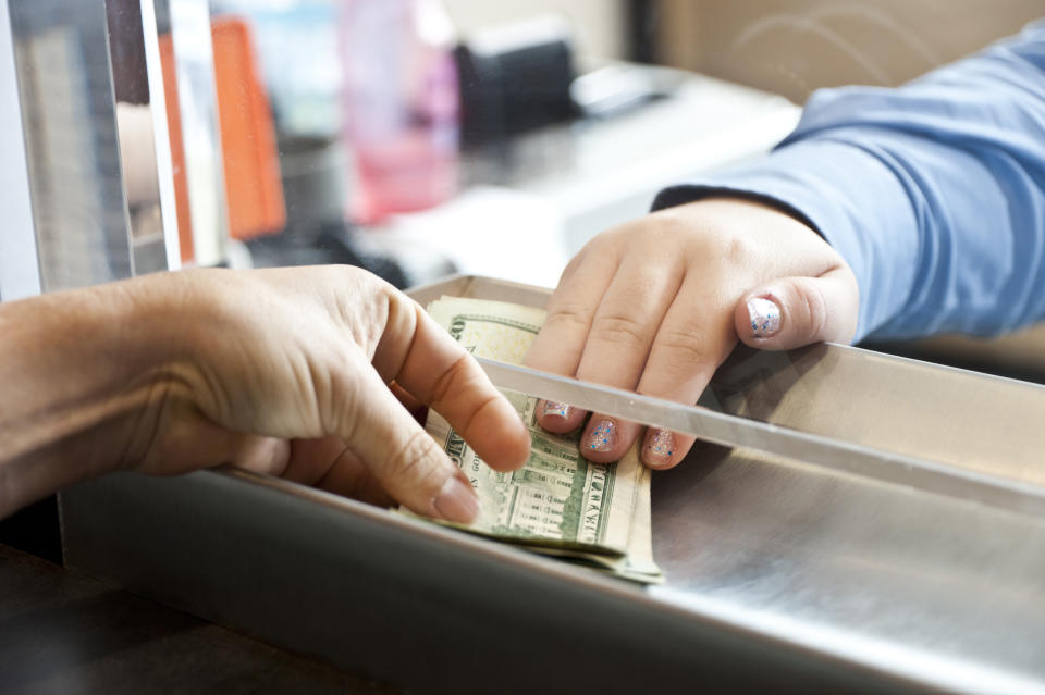 manos de mujer recibiendo dinero en el banco