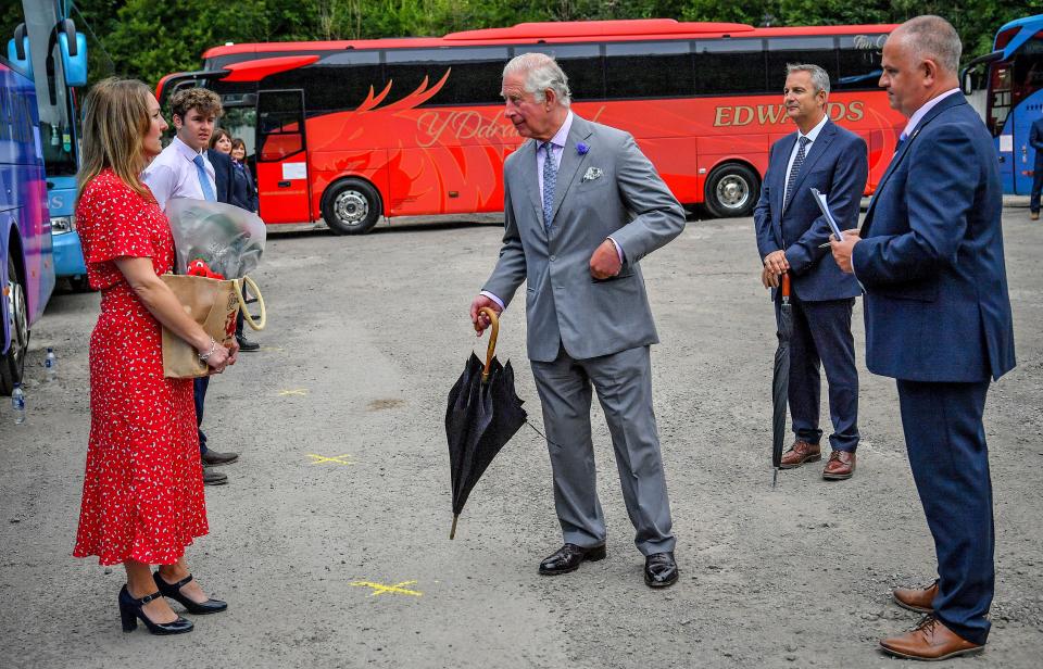 Britain's Prince Charles, Prince of Wales (C) reacts during his visit to family run travel and holiday business, Edwards Coaches, in Abercynon, near Mountain Ash, south Wales, on July 13, 2020. - The company has been impacted by the COVID-19 pandemic, but is now beginning to restart some of their operations. (Photo by Ben Birchall / POOL / AFP) (Photo by BEN BIRCHALL/POOL/AFP via Getty Images)