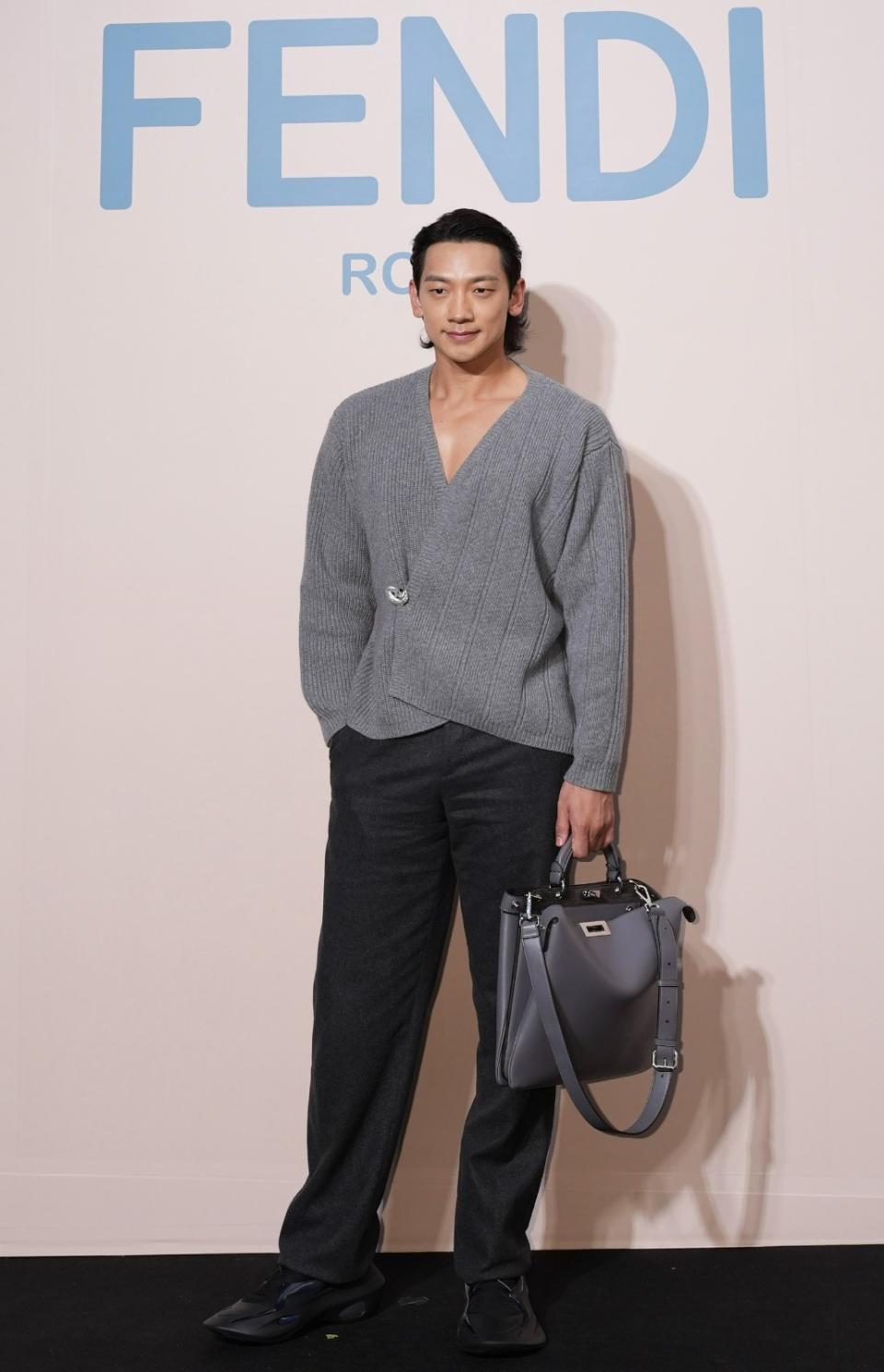 Rain porte une veste en fourrure cardigan grise et un pantalon noir.