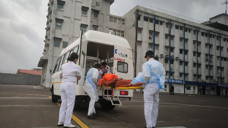 This photograph provided by Indian navy shows, one of the people rescued by the navy from the Arabian sea being brought for medical attention at naval air station INS Shikra in Mumbai, India, Tuesday, May 18, 2021. The Indian navy is working to rescue crew members from a sunken barge and a second cargo vessel that was adrift Tuesday off the coast of Mumbai after Cyclone Tauktae, struck the western coast. (Indian Navy via AP)