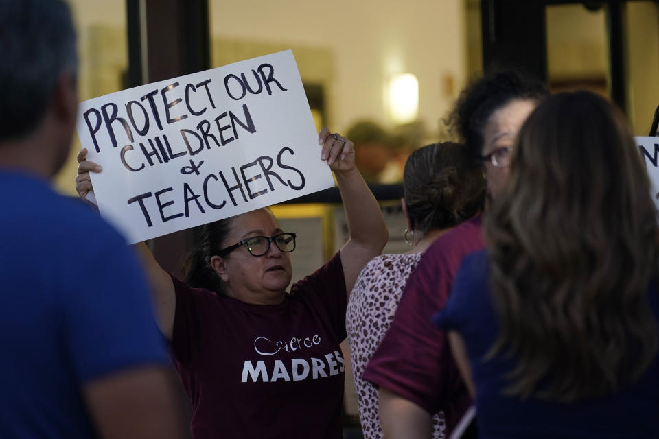 Parents and family of students hold protest signs during a special meeting of the Board of Trustees of Uvalde Consolidated Independent School District where parents addressed the shootings at Robb Elementary School, Monday, July 18, 2022, in Uvalde, Texas. (AP Photo/Eric Gay)