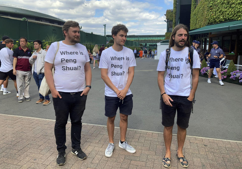 From left Protesters Will Hoyles, 39, Caleb Compton, 27, and Jason Leith, 34, who all work for Free Tibet pose for the media in T-shirts reading "Where is Peng Shuai", at the Wimbledon Tennis tournament in London, Monday, July 4, 2022. Four activists wearing “Where is Peng Shuai?” T-shirts were stopped by security at Wimbledon on Monday and had their bags searched. (Rebecca Speare-Cole/PA via AP)