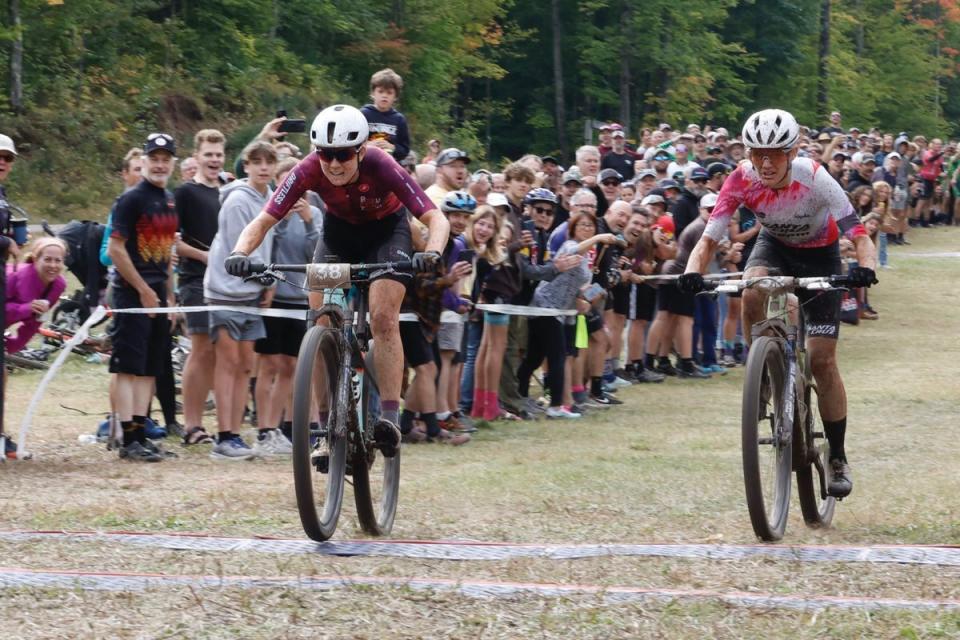 a person riding a bike on a dirt track with a crowd watching