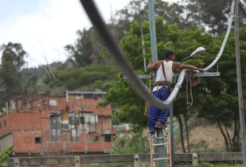 A man works on a pipe from a community-made water system that bring water that accumulated at a stalled tunnel construction project near El Avila mountain that borders the city of Caracas
