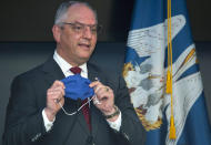 Louisiana Gov. John Bel Edwards holds up his own mask, taken off while he was speaking, to remind Louisiana residents that a highly effective thing within their power to do to prevent the spread of COVID-19 is to simply wear a mask, Tuesday, July 28, 2020, at a press conference update on the state's COVID-19 situation at the Governor's Office of Homeland Security and Emergency Preparedness in Baton Rouge, La. (Travis Spradling/The Advocate via AP, Pool)