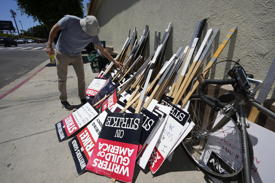 A picketer selects a sign outside Paramount Pictures during a Writers Guild rally on Thursday, July 13, 2023, in Los Angeles. The rally follows a press conference announcing a strike by The Screen Actors Guild-American Federation of Television and Radio Artists. This marks the first time since 1960 that actors and writers will picket film and television productions at the same time. (AP Photo/Mark J. Terrill)