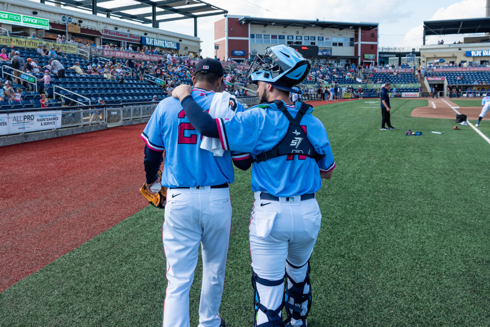 Blue Wahoos catcher Will Banfield walks with starting pitcher Luis Palacios before Sunday's game at Blue Wahoos Stadium.