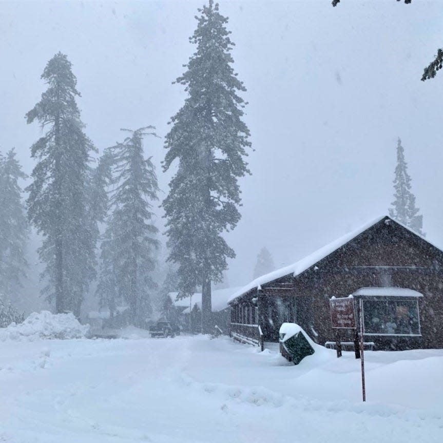 Snow falls near the Kings Canyon Visitor Center on Tuesday. The national parks will close this weekend as another winter storm buffets the Sierra Nevada.