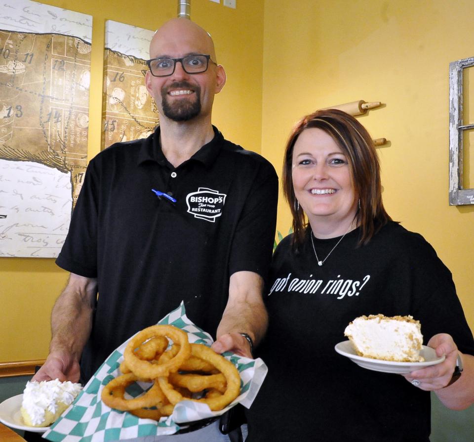 Bishops Restaurant new owners Jason and Traci Knuch hold two of the most popular selling items, onion rings and homemade pie.