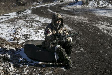 A fighter with the separatist self-proclaimed Donetsk People's Republic Army sits at a checkpoint along a road from the town of Vuhlehirsk to Debaltseve in Ukraine, in this picture taken February 18, 2015. REUTERS/Baz Ratner