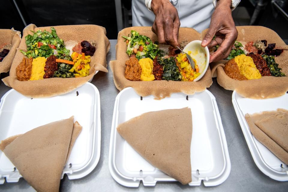 Three open boxes of vegetarian takeout orders.