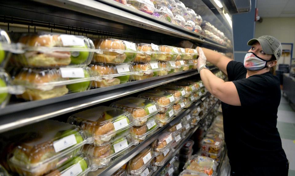 Dina Wiroll, director of nutritional services at Assabet Valley Regional Technical High School in Marlborough, stocks the grab 'n' go display in the school's cafeteria.