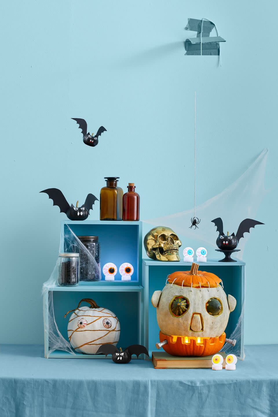 <p>Paint any mini pumpkin black, use white-painted pumpkin seeds for teeth and cut ears and wings out of cardstock. Glue googly eyes on top of eye-shaped paper cutouts to finish of these spooky gourds.</p>