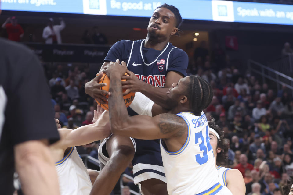 Arizona guard Cedric Henderson Jr., top, and UCLA guard David Singleton (34) vie for a rebound during the first half of an NCAA college basketball game for the championship of the men's Pac-12 Tournament, Saturday, March 11, 2023, in Las Vegas. (AP Photo/Chase Stevens)