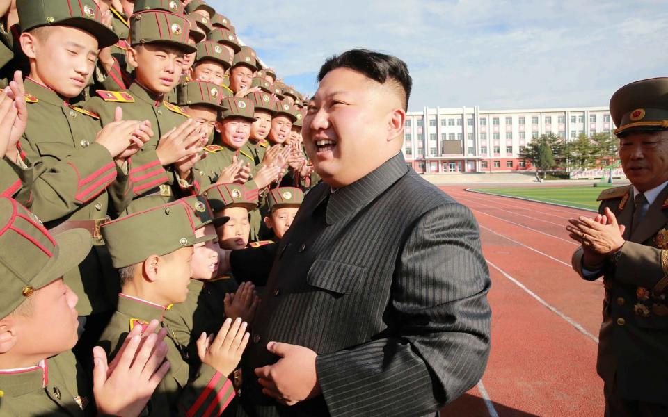 This undated photo released by North Korea's official Korean Central News Agency (KCNA) on October 13, 2017 shows North Korean leader Kim Jong-Un (C) photographed with students and teachers of Mangyongdae Revolutionary School in Pyongyang - AFP