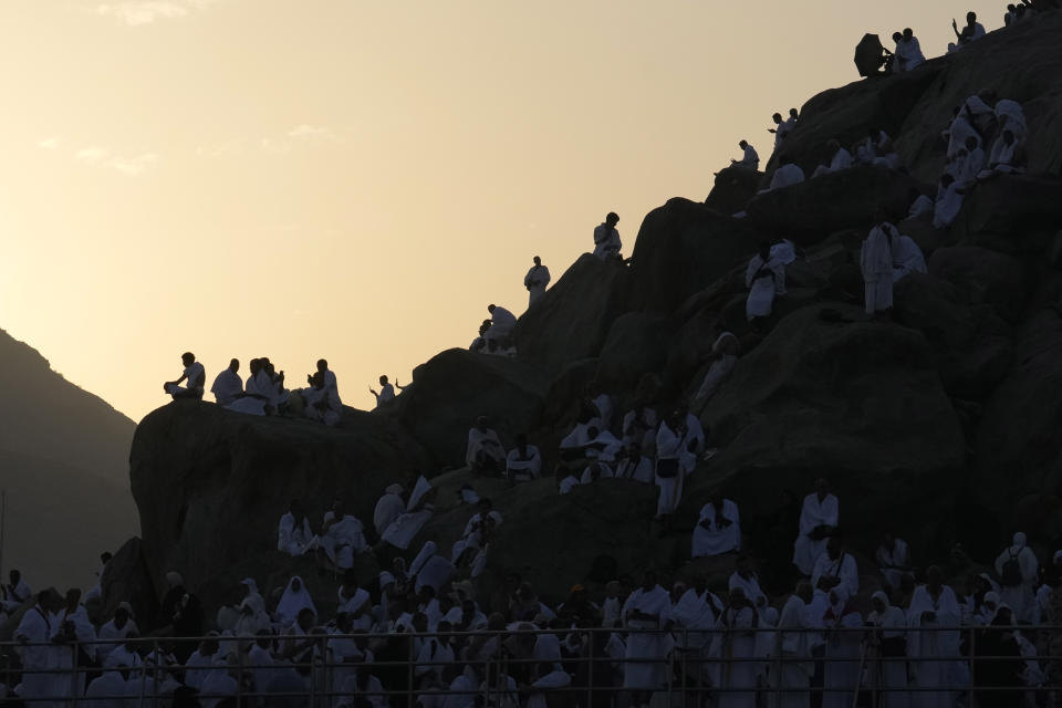 Peregrinos musulmanes se congregan en la cima de una colina rocosa conocida como la montaña de la misericordia, en la llanura de Arafat, durante la peregrinación anual del haj, cerca de la ciudad santa de La Meca, Arabia Saudí, el 15 de junio de 2024. (AP Foto/Rafiq Maqbool)