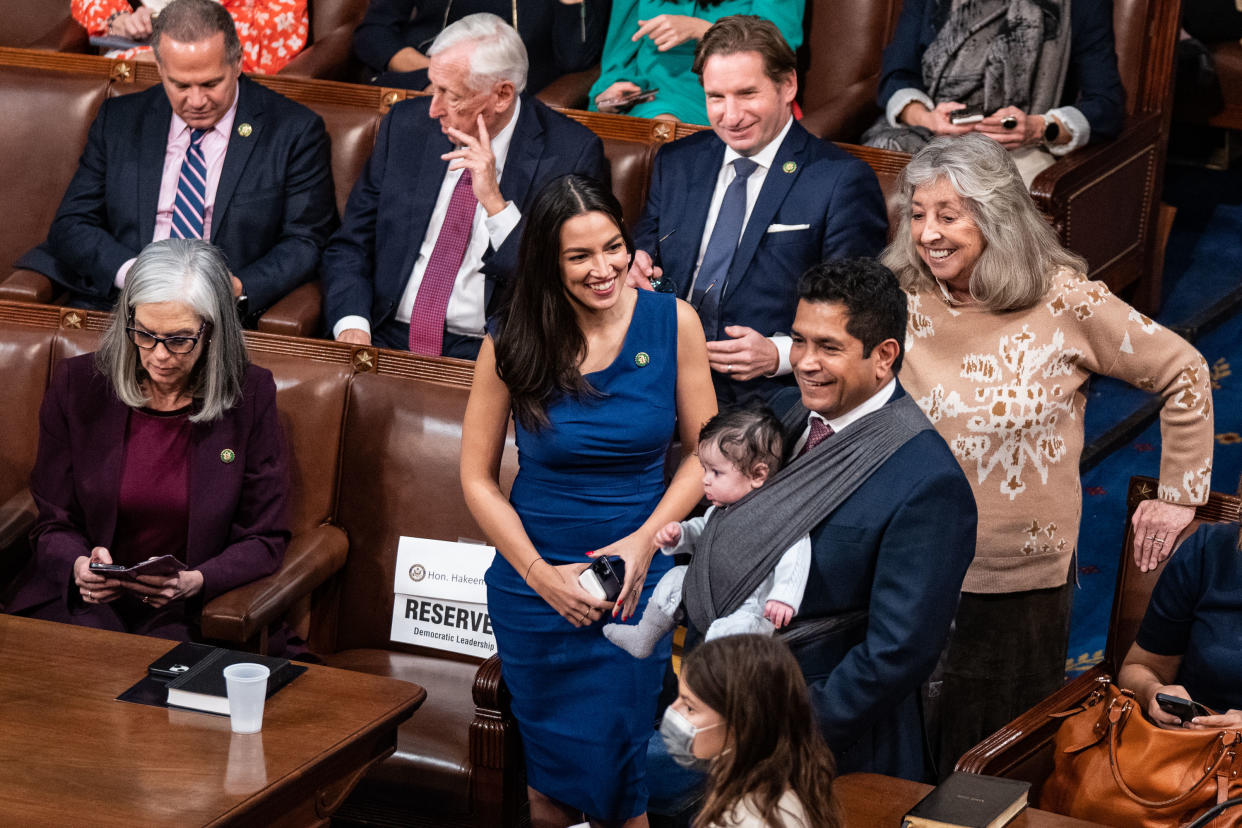 El representante Jimmy Gómez (demócrata de California) lleva a su hijo Hodge en bandolera durante la serie de votaciones para presidente de la Cámara de Representantes, en el Capitolio, en Washington, el 3 de enero de 2023. (Haiyun Jiang/The New York Times)