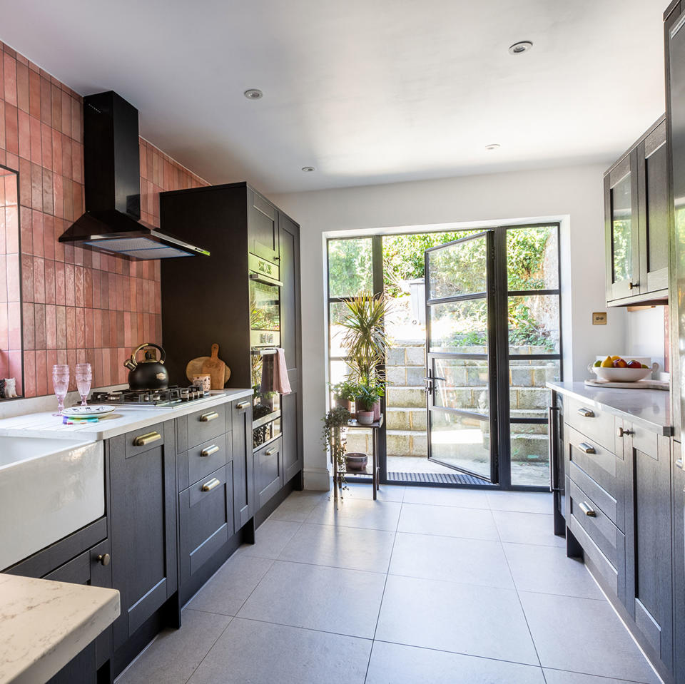 black kitchen cabinets with pink tiles