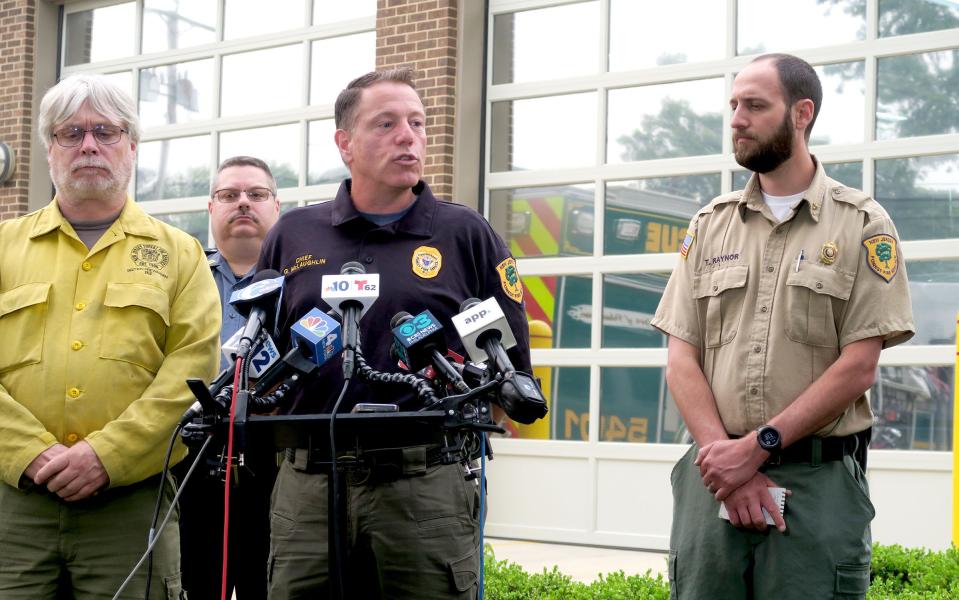 NJ Forest Fire Service Chief Greg McLaughlin (center) speaks Tuesday evening, June 6, 2023, about the Jackson "Glory" brush fire.  Also shown are: Assistant Fire Warden Trevor Raynor (right), Section Fire Warden Deale Carey  and Jackson Police Captain John Giovanetti (left).   