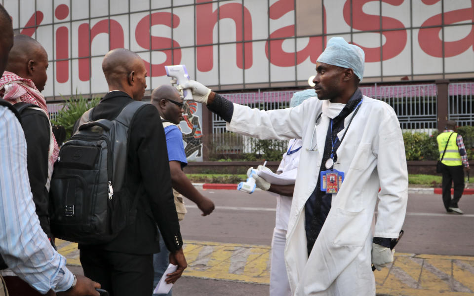 FILE - In this Saturday, June 2, 2018 file photo, a health worker checks the temperature of people disembarking from a plane at the airport in Kinshasa, Congo. The World Health Organization says Ebola deaths in Congo's latest outbreak are expected to exceed 1,000 later on Friday, May 3, 2019. WHO's emergencies chief made the announcement at a news conference in Geneva. The Ebola outbreak that was declared in eastern Congo in August is already the second deadliest outbreak in history, and efforts to control it have been complicated by a volatile security situation and deep community mistrust. (AP Photo/Sam Mednick, File)