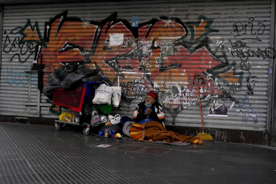 Un hombre sin hogar se sienta en una calle cerca de Plaza de Mayo en Buenos Aires, Argentina, el jueves 14 de julio de 2022. (AP Foto/Natacha Pisarenko)