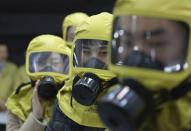 <p>Beamte der südkoreanischen Regierung tragen während einer Rettungsübung in Seoul Gasmasken – sie trainieren das Verhalten bei einem chemischen Angriff durch Nordkorea. (Bild: Ahn Young-joon/AP) </p>