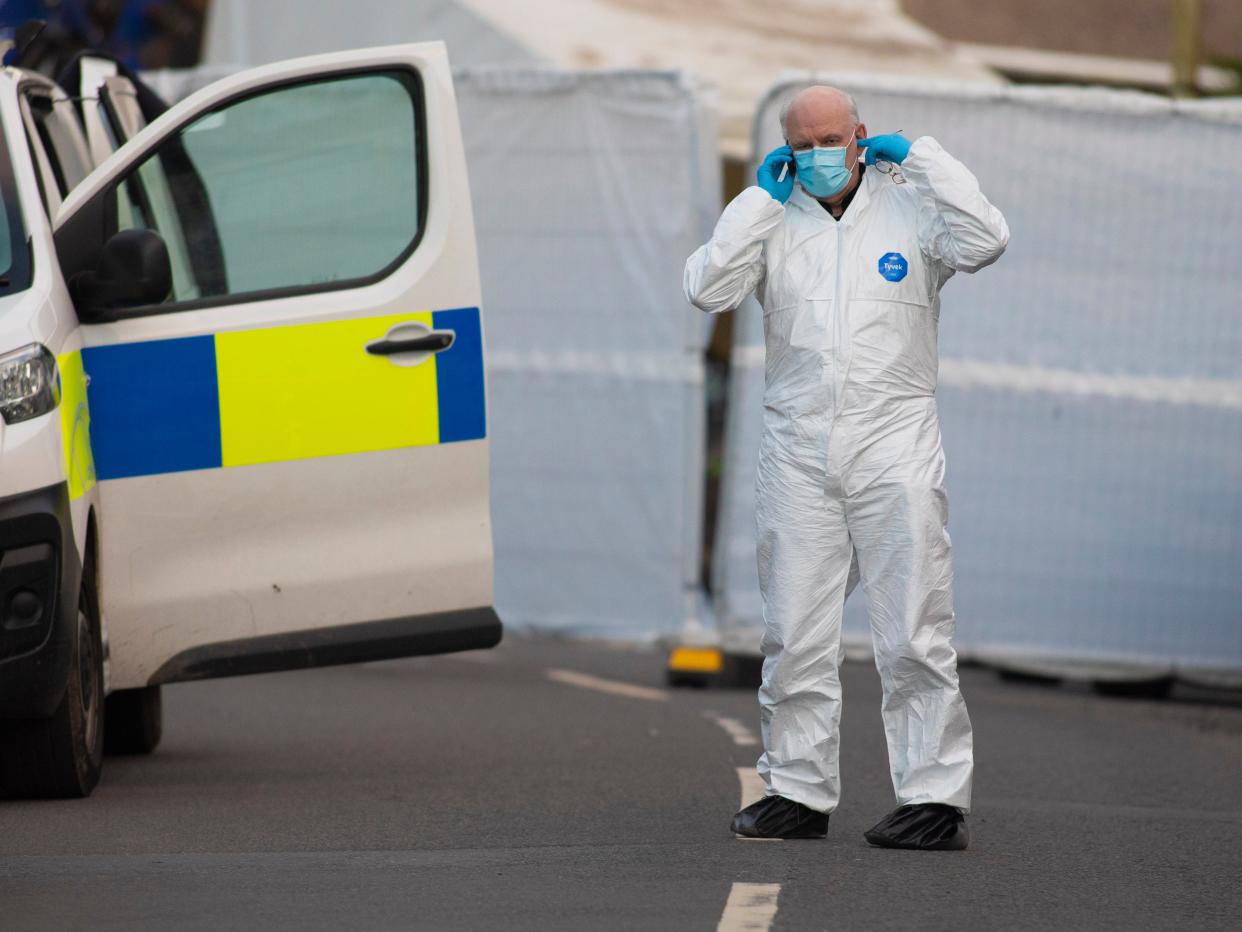 <p>A forensic officer is seen on Baglan Street, Treorchy, after Friday’s incident </p> (EPA)