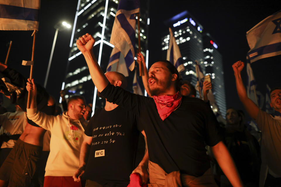 Israelis opposed to Prime Minister Benjamin Netanyahu's judicial overhaul plan block a highway during a protest moments after the Israeli leader fired his defense minister, in Tel Aviv, Israel, Sunday, March 26, 2023. Defense Minister Yoav Gallant had called on Netanyahu to freeze the plan, citing deep divisions in the country and turmoil in the military. (AP Photo/Oren Ziv)