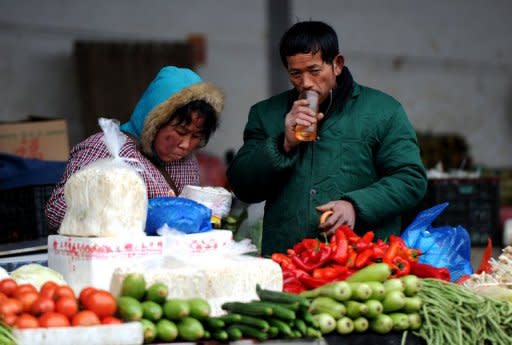 Vendors wait for customers at a vegetable market in Hefei, east China's Anhui province, last month. China's inflation rate edged up in March from the previous month, according to official data, as bad weather pushed up food prices and authorities raised the price of fuel