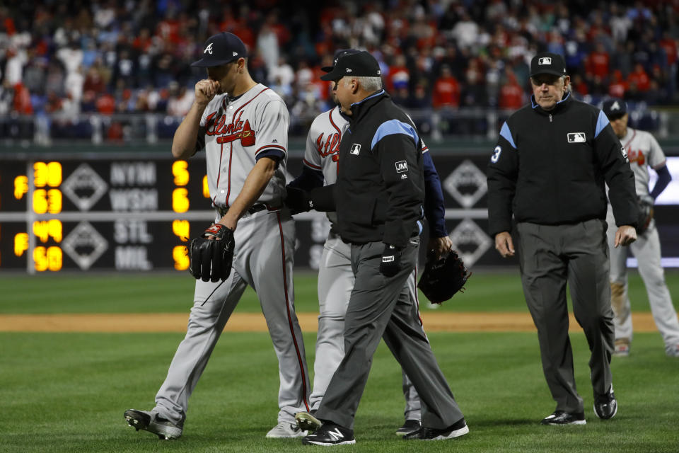 Atlanta Braves relief pitcher Shane Carle, left, walks off the field after being ejected for hitting Philadelphia Phillies' Rhys Hoskins with a pitch during the seventh inning of a baseball game, Sunday, March 31, 2019, in Philadelphia. (AP Photo/Matt Slocum)