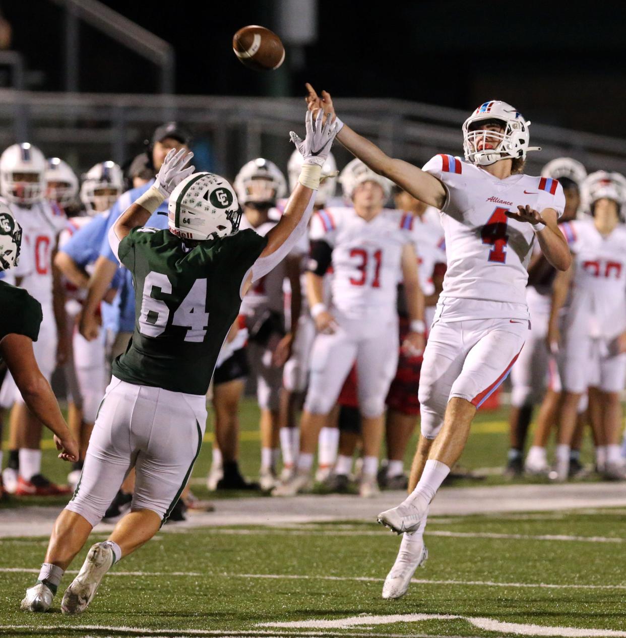 Brendan Zurbrugg, 4, of Alliance targets a receiver while being pressured by Thomas Buckler, 64, of Central Catholic  during their game at Central Catholic on Friday, Sept. 16, 2022. 